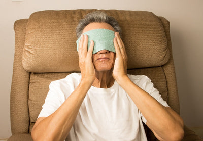 Close-up of a person gently pressing along the lower eyelid margin after warming the lids