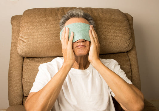 Close-up of a person gently pressing along the lower eyelid margin after warming the lids